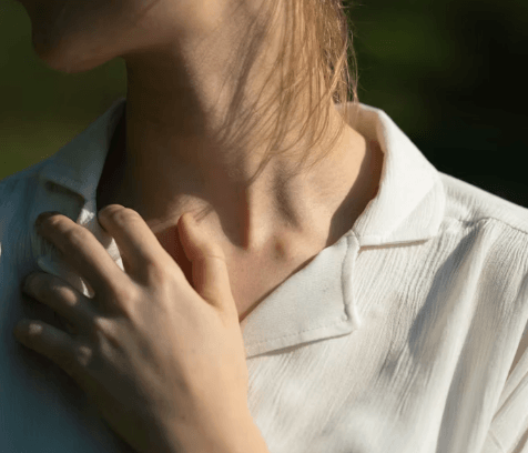 Woman experiencing Thyroid symptoms in her thyroid gland